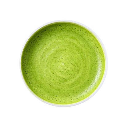 Ceremonial matcha green tea powder brewed into a vibrant green tea drink with smooth foam texture and fresh natural color