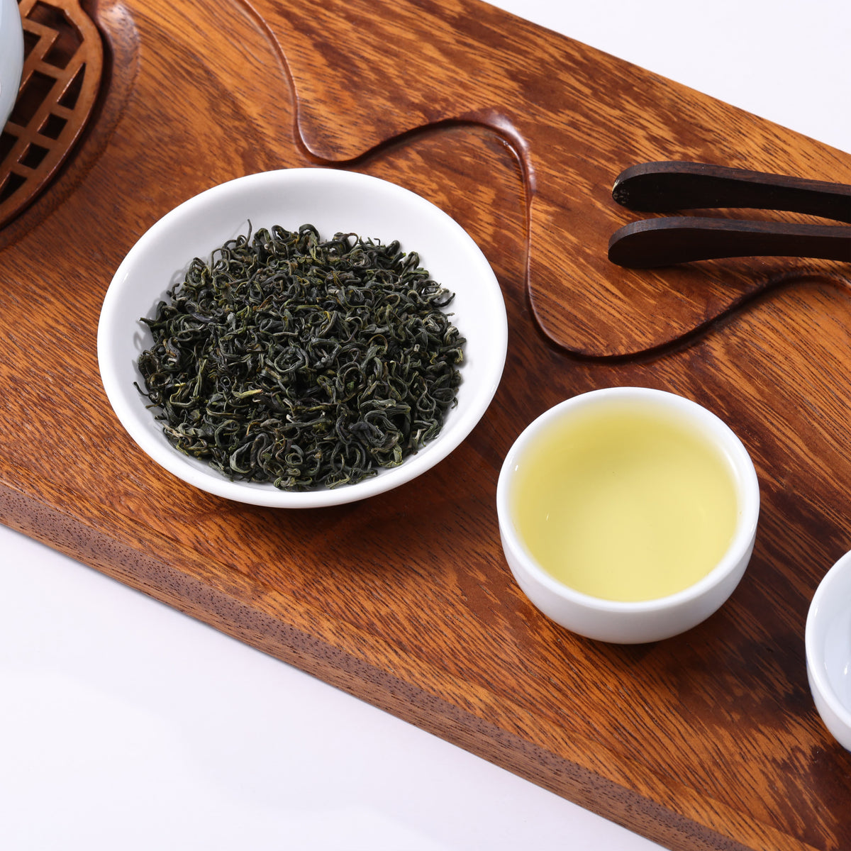 Premium Enshi selenium green tea with dark green curled leaves and clear light green tea liquor.
