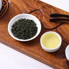 Premium Enshi selenium green tea with dark green curled leaves and clear light green tea liquor.