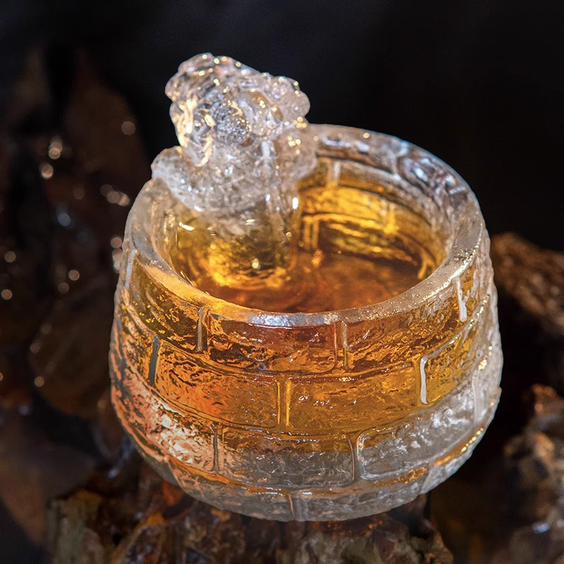 Close-up of a handcrafted glass teacup with a detailed Great Wall brick texture, featuring an auspicious lion sculpture glowing with golden tea.
