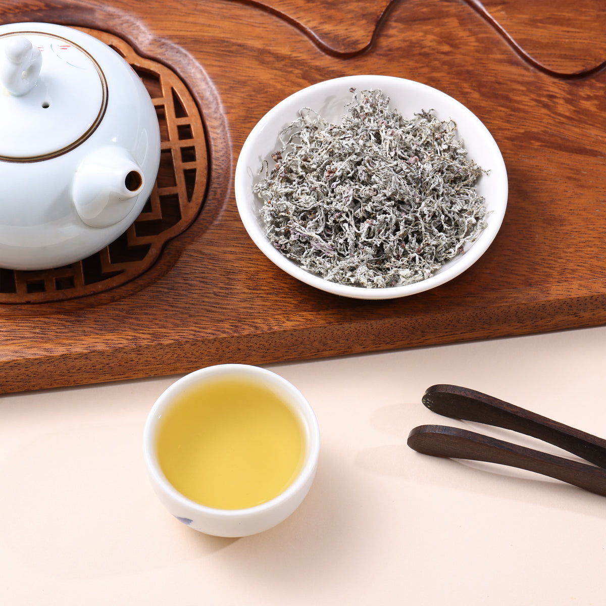 Laifeng vine tea buds with pale golden tea liquor displayed in a traditional Chinese tea setting.