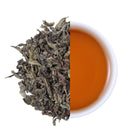 Premium Laifeng Vine Tea large leaves and amber tea infusion comparison, showcasing the natural leaf texture and rich flavor of caffeine-free herbal tea from Hubei, China