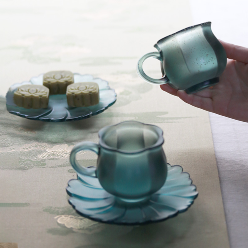 Elegant misty teal glass tea set and snack dish showcasing a sophisticated oriental hosting style with a soft-focus lifestyle atmosphere.