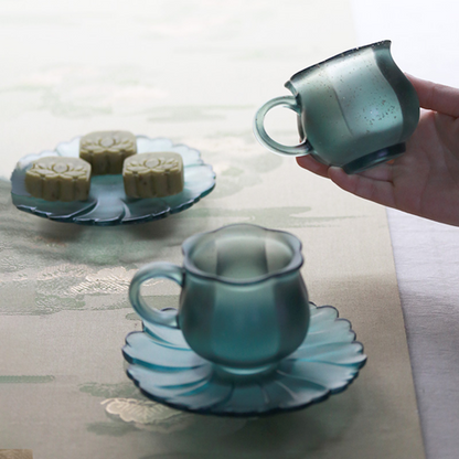 Elegant misty teal glass tea set and snack dish showcasing a sophisticated oriental hosting style with a soft-focus lifestyle atmosphere.