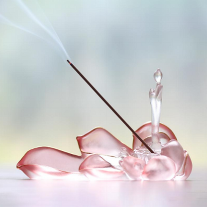 An elegant pink translucent lotus-shaped glass incense holder with wisps of smoke, captured in a bright and serene atmosphere for a mindful home ritual.