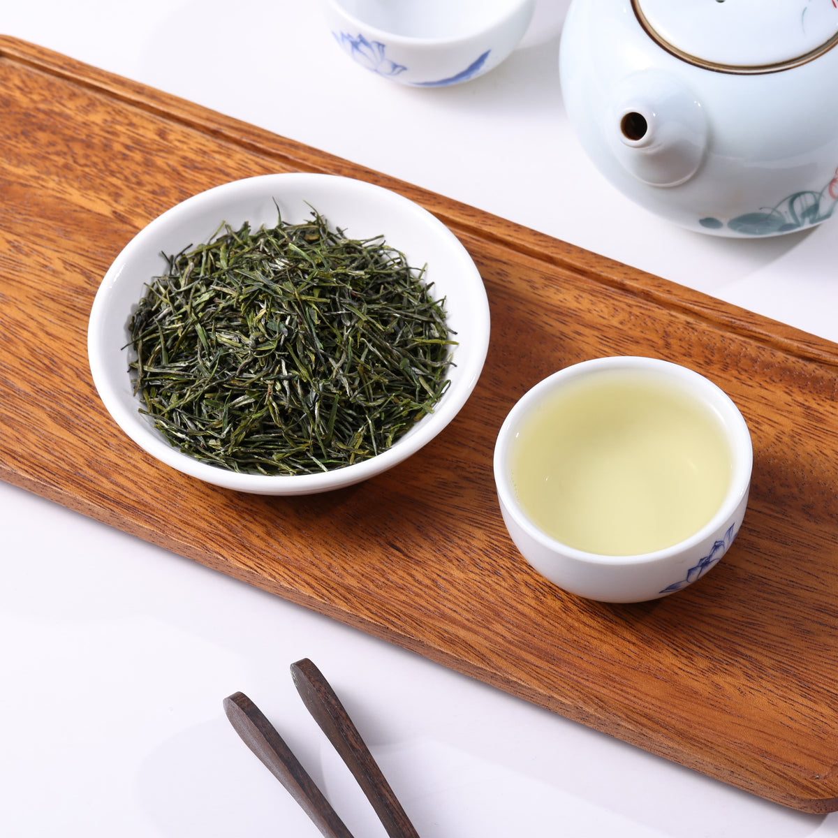 Premium Enshi Yulu steamed green tea with needle-shaped leaves and clear pale green tea liquor.