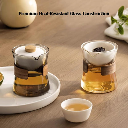 Two premium heat-resistant glass tea makers, featuring clear and smoked grey variants, brewing golden tea on a warm wooden table.