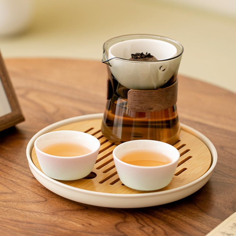 A complete SeTeng Tea smoked grey glass tea set, including a rotational brewer, two tasting cups, and a bamboo tray, elegantly arranged on a wooden table.