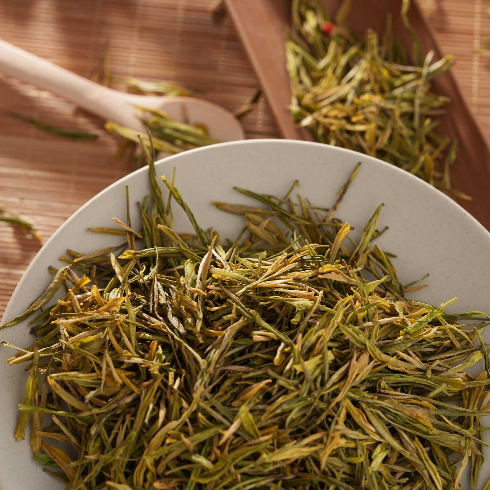 Premium SeTeng Milk White Tea showcasing delicate, straight golden-green loose leaves, elegantly displayed in a white ceramic bowl.