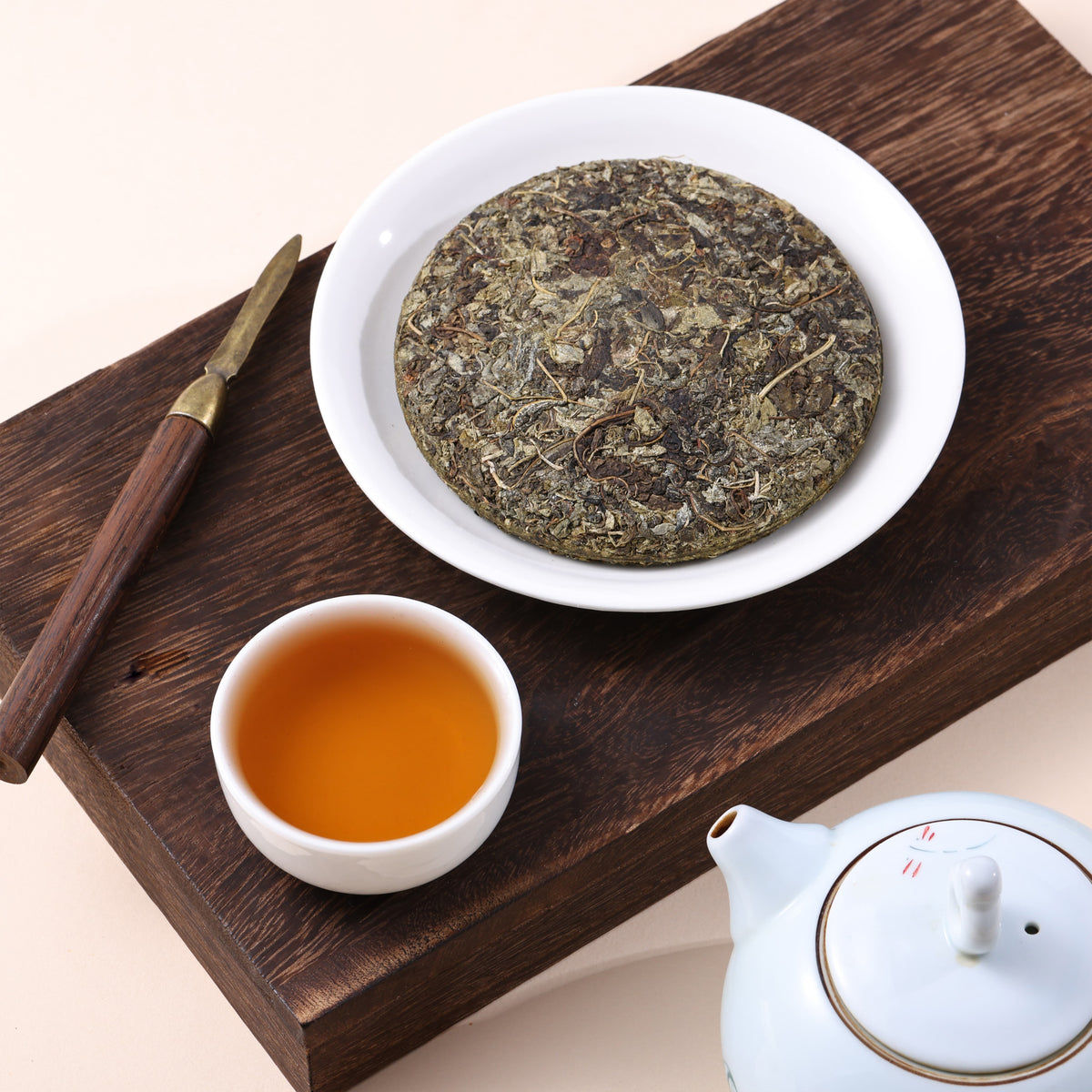 Six-year fermented vine tea cake served with clear amber tea liquor in a traditional tea setting.