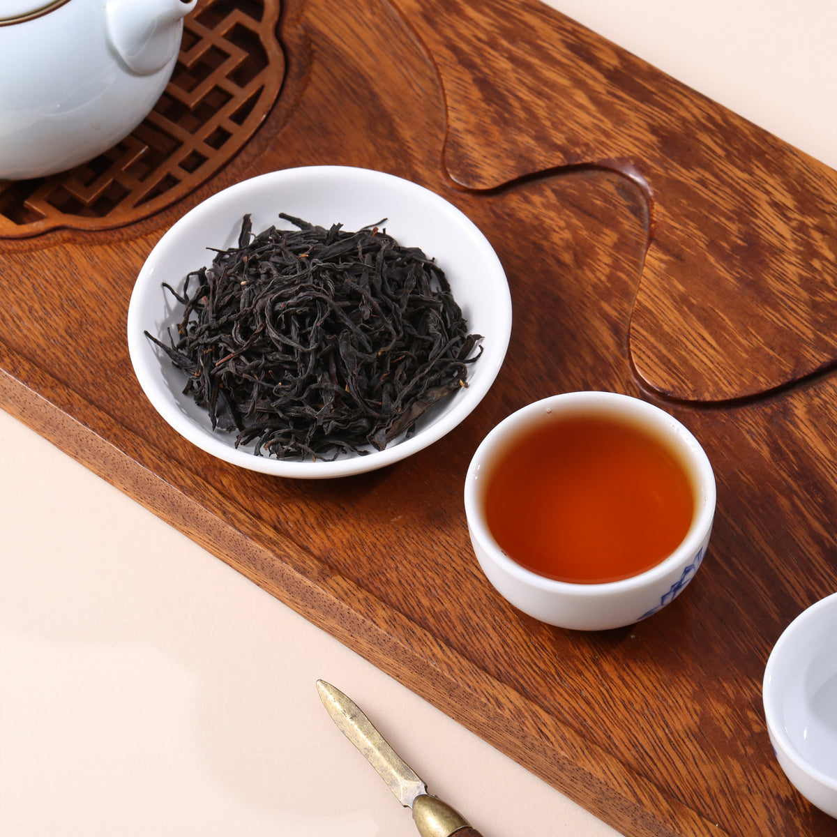 Chinese wild black tea with dark twisted leaves and bright reddish amber tea liquor.