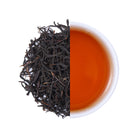 Premium wild-grown black tea from China, featuring natural loose leaf tea leaves and a rich amber-red tea infusion with a deep aroma