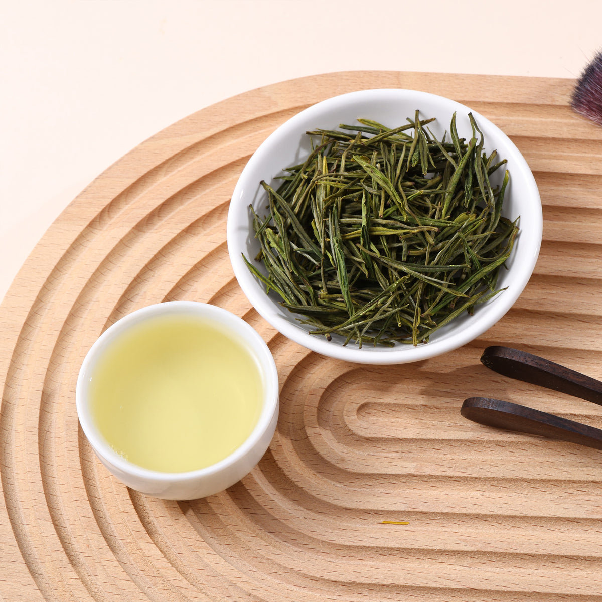 Xianfeng white green tea with straight green leaves and clear pale yellow tea liquor.